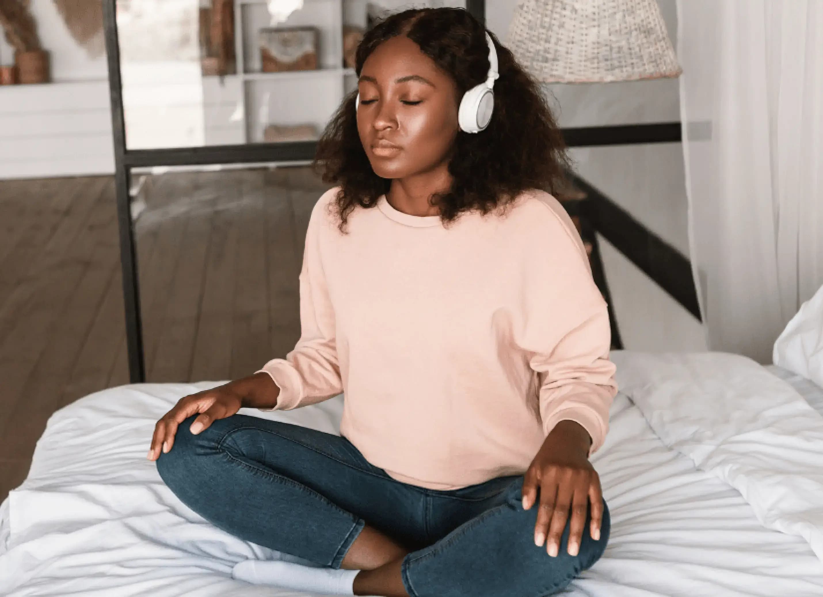 Zwangere vrouw doet thuis op bed de audiocursus mindful zwanger