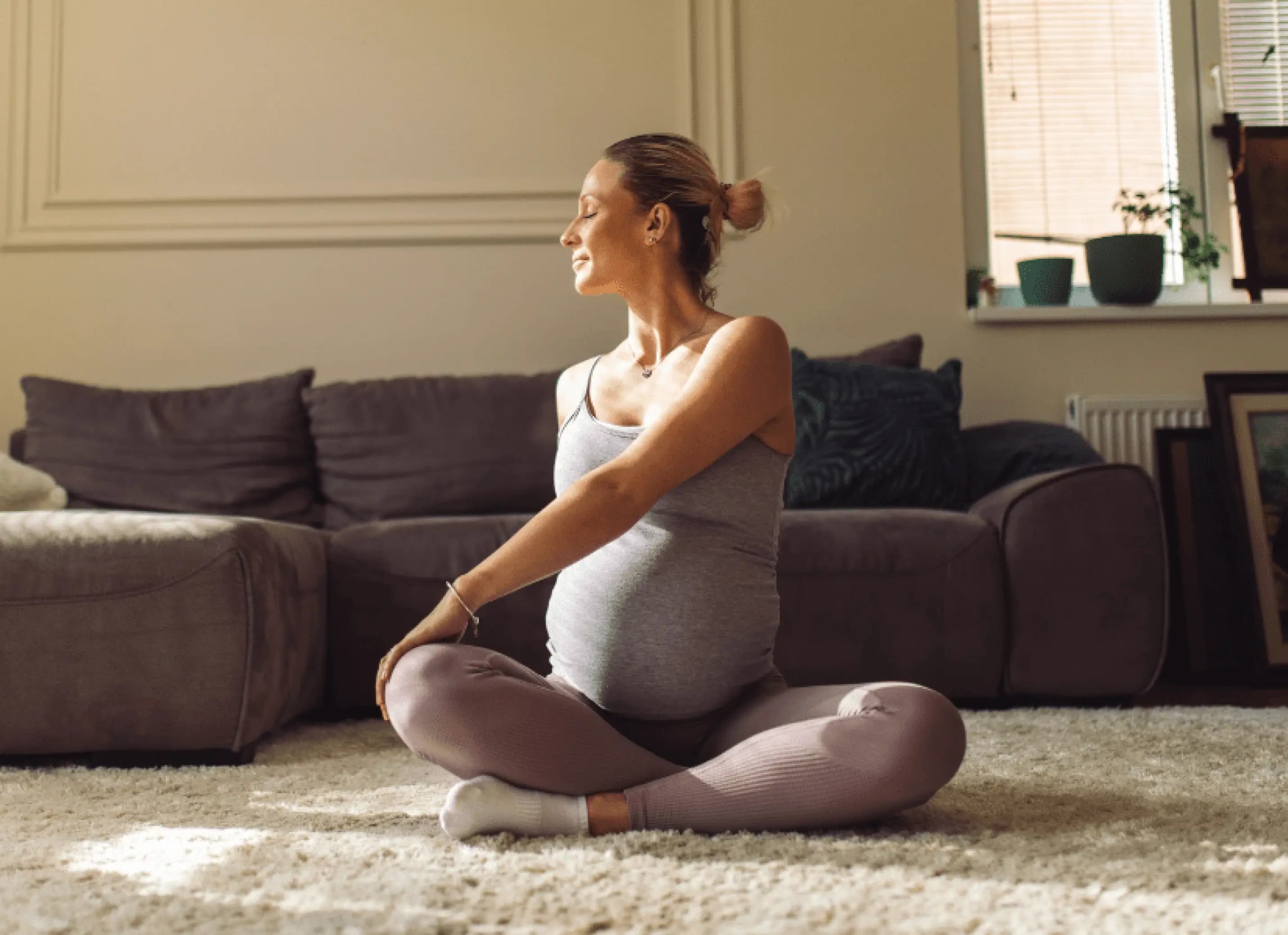 Zwangere vrouw doet thuis een cursus zwangerschapsyoga